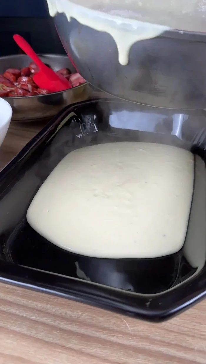 Colocar una parte de la salsa blanca en el fondo de una bandeja para hornear.