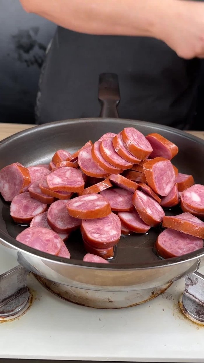 Cortar la cebolla en rodajas finas. Freír la calabresa junto con la cebolla hasta que estén doradas y liberen su aroma. Mezclar bien para que se doren uniformemente.