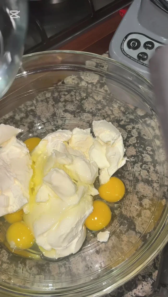 En un bol, mezcla 900 g de queso crema Philadelphia, 5 huevos, 1 taza de azúcar, 0.5 litros de nata para montar, 1 cucharada de fécula de maíz y un poco de vainilla.