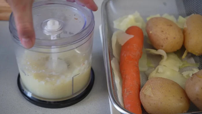 Triturar el repollo en el procesador de alimentos, pasarlo por un colador para eliminar el exceso de agua.
