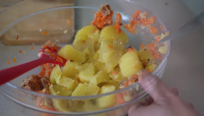 Mezclar la cebolla, el bacon triturado, el repollo, la zanahoria y las patatas en un bol. Agregar sal y pimienta al gusto.