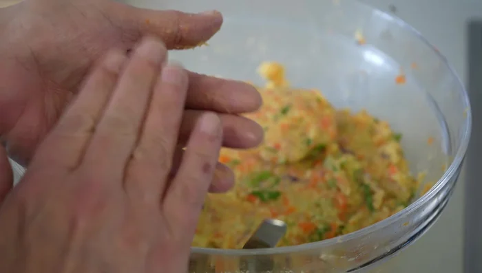 Formar las tortitas con una cuchara, colocando un trozo de queso en el centro y cubriéndolo con más masa.