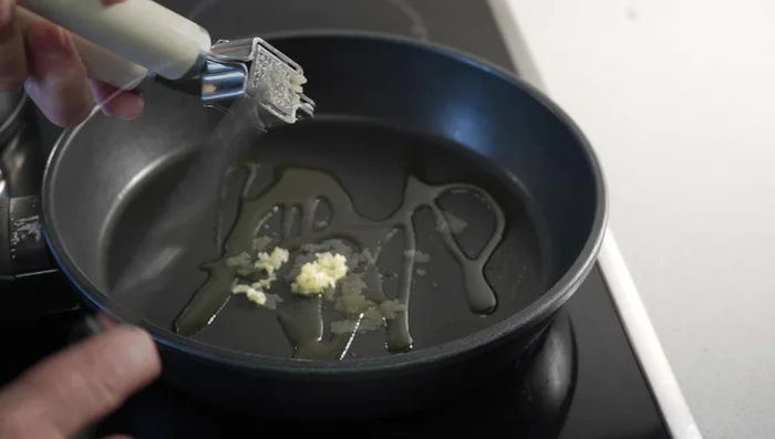 Sofreír la cebolla con ajo picado en aceite de oliva hasta que esté dorada.
