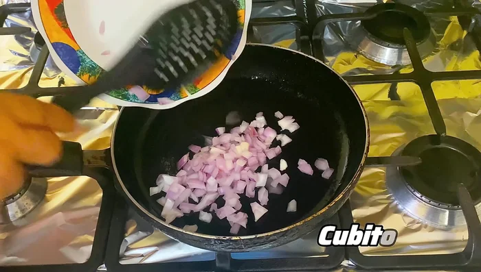 Agregar la cebolla a la sartén junto con una cucharada de pasta de ajo y mezclar bien (61.199 seg).