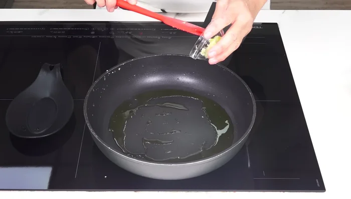 Añadir otra cucharada de aceite a la sartén. Sofreír el ajo picado hasta que esté dorado.