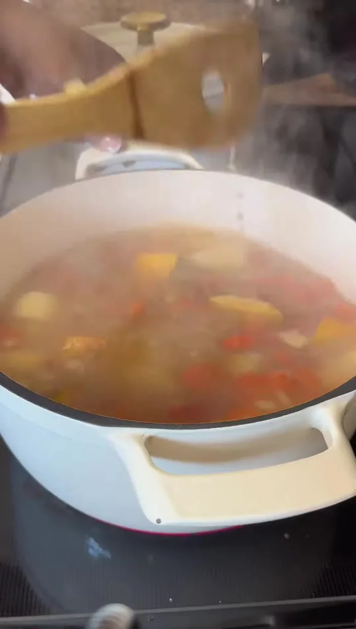 Agregar las paticas, añadiendo agua primero para evitar que se quemen. Agregar sazonador con achiote (bija), para dar color, y una cucharada grande de agrio de naranja.