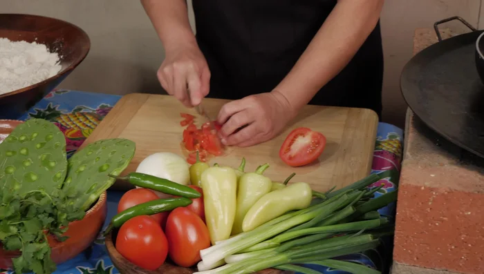Preparar la salsa: picar finamente los tomates, chiles serranos, cebolla y cilantro. Mezclar todo con un poco de sal.