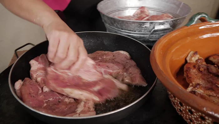 Calentar el comal con un poco del aceite de las chuletas. Agregar los chiles, cebolla y nopales, cocinando hasta dorar.