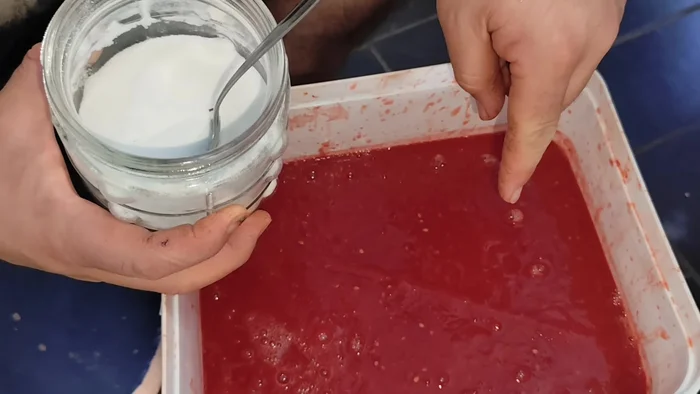 Agregar sal, orégano, ajo y perejil seco a la salsa de tomate triturada. Mezclar bien con una cuchara de madera.