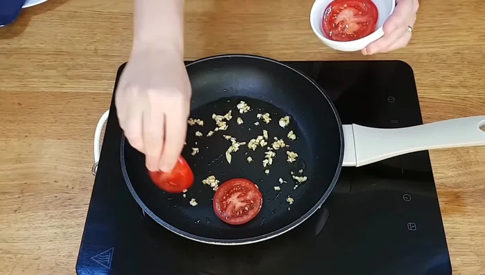 Incorporar el tomate, bajar el fuego al mínimo y sazonar con sal.