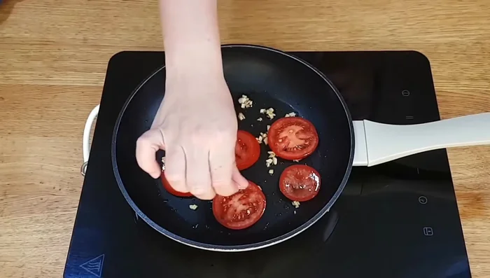 Tapar la sartén y cocinar hasta que el tomate esté cocido.
