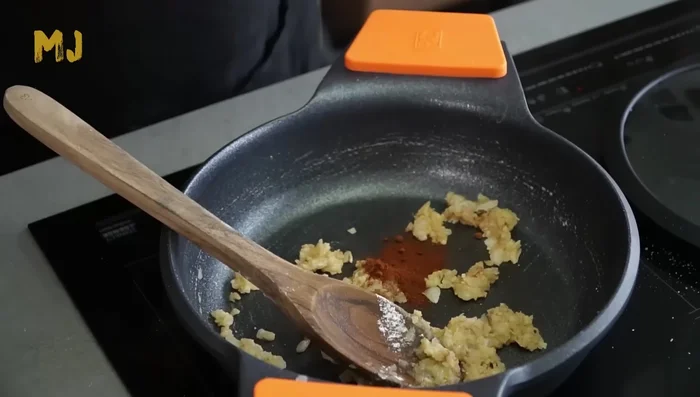 Agregar el pimentón, remover y añadir el tomate triturado. Sofreír durante 10 minutos.