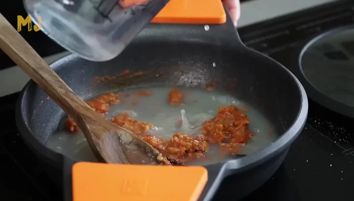 Verter el caldo de mejillones y el agua. Cocinar a fuego fuerte durante 10 minutos.