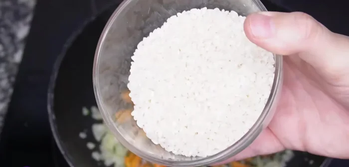 Agregar el arroz y cocinarlo durante 1 minuto. Agregar los 50 ml de vino blanco restantes y dejar evaporar el alcohol.