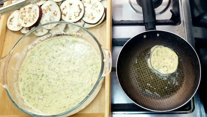 Pasar las rodajas de berenjena por la masa, asegurándose de que queden bien cubiertas.