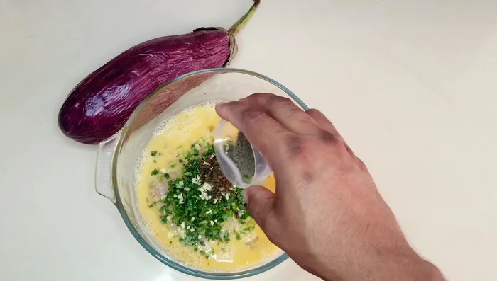 Agregar a los huevos batidos la cebolla, los pimientos, el cilantro, el ajo, el orégano, la pimienta, el sazón en polvo, la sal y la harina. Mezclar bien con un tenedor o batidor hasta obtener una masa un poco espesa (agregar agua si se desea una masa más suave).