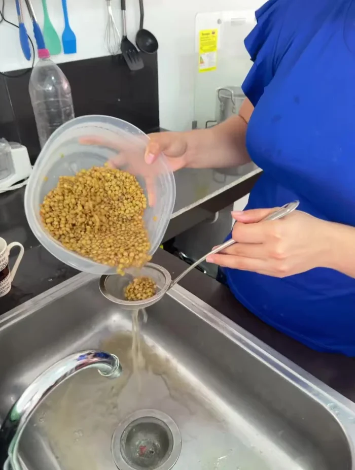 Después de los 15 minutos de reposo, escurrir el agua caliente de las lentejas y lavarlas con agua fría.