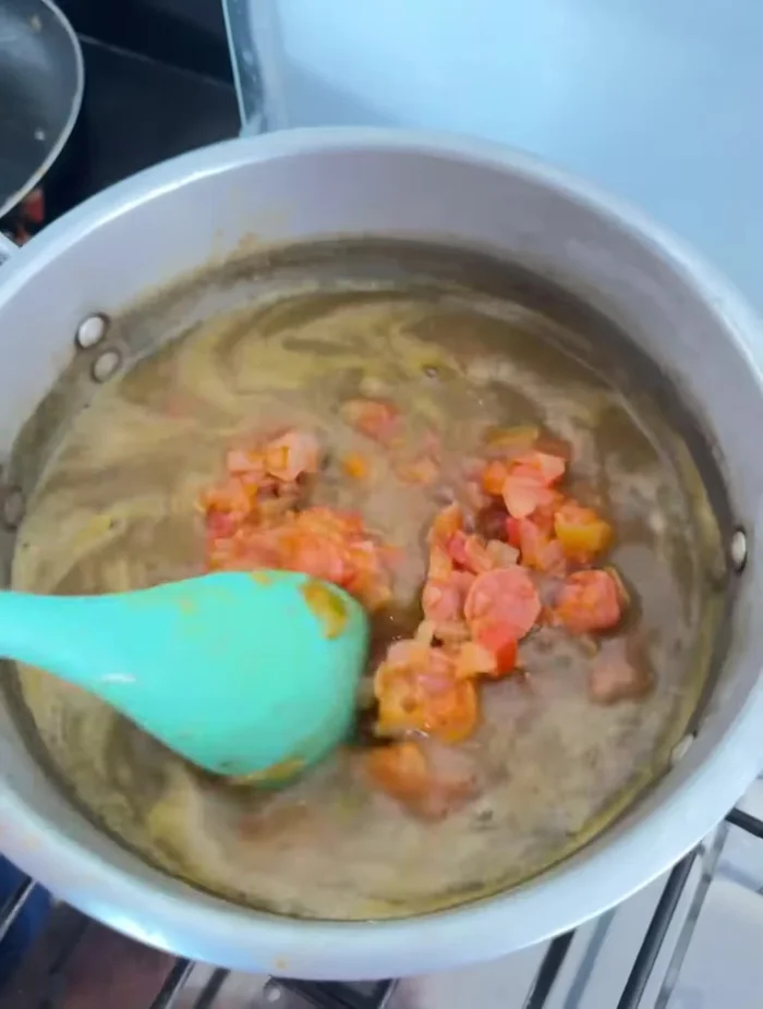 Agregar el sofrito de salchicha, cebolla y tomate a las lentejas.
