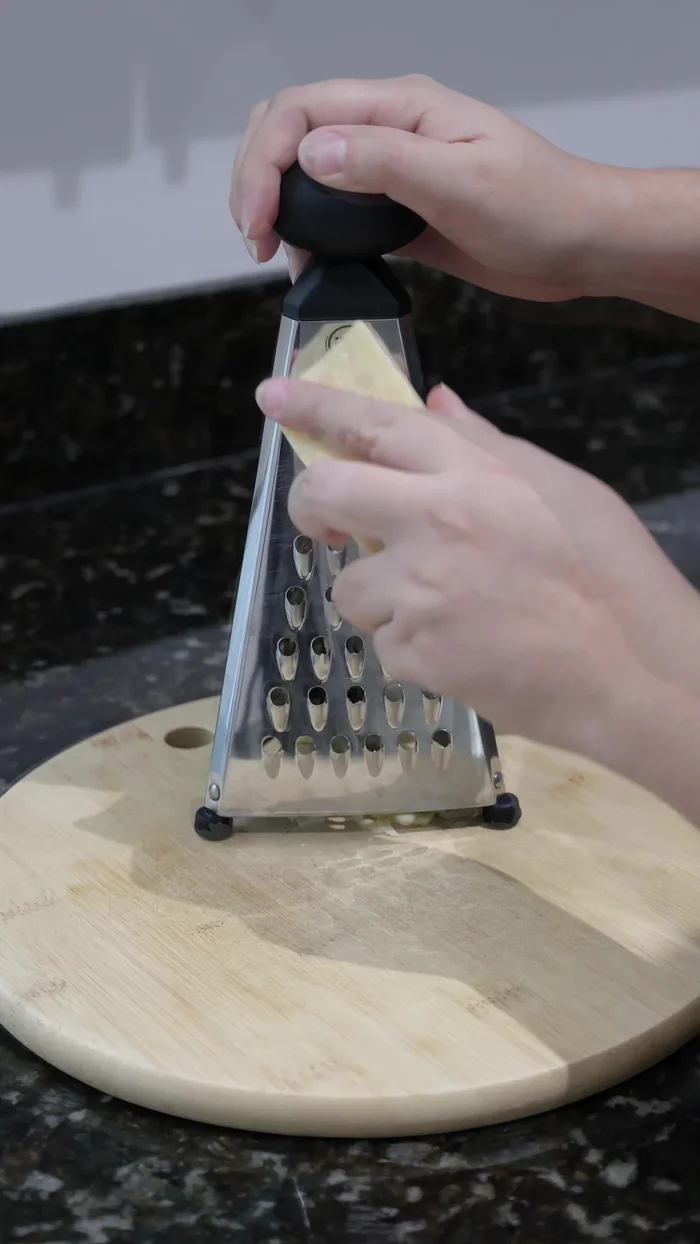 Rallar un trozo de queso.