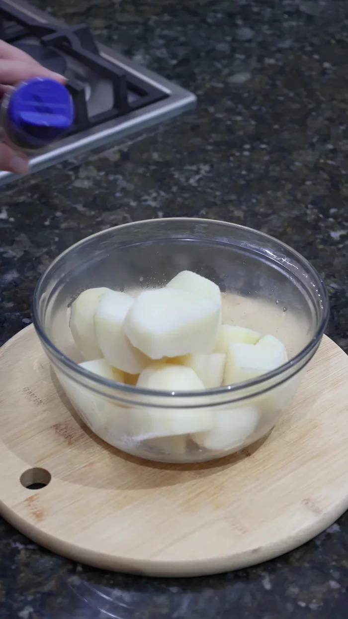 Una vez cocidas y frías, machacar las papas en un recipiente grande. Agregar sal, pimienta negra molida, un huevo y mezclar bien.