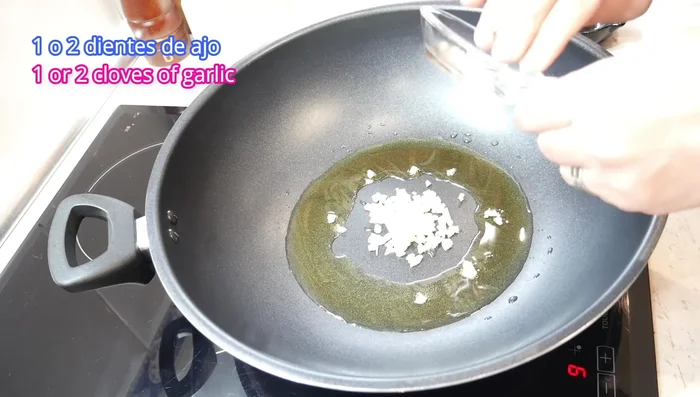 Cocina el huevo: En un wok o sartén con aceite caliente, añade el ajo picado y dora ligeramente. Agrega los huevos batidos y forma un revuelto jugoso. Reserva. (143.04)