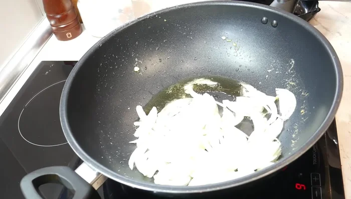 Sofríe las verduras: En el mismo wok, añade la cebolla y las zanahorias cortadas en juliana y bastoncillos, respectivamente. Saltea hasta que estén al dente. (211.48)