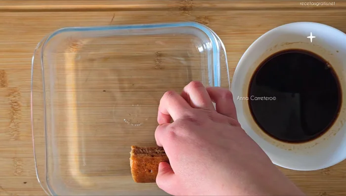 Baña rápidamente las galletas de soletilla en el café.