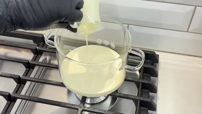 En una olla, coloca los 500g de crema de leche a fuego medio. Revuelve ocasionalmente.