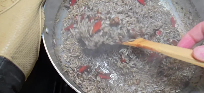 Remueve el arroz para que se seque el agua, vuelve a tapar y baja el fuego.
