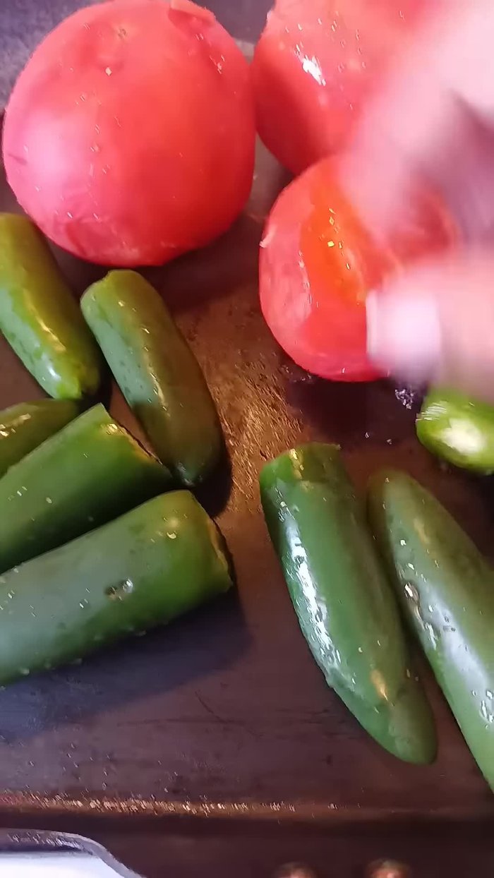 Preparar la salsa: Asar los chiles y tomates en el comal.