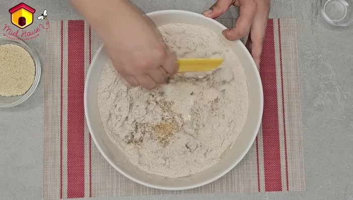 Amasar la masa hasta que se integren todos los ingredientes. Agregar más agua o harina si es necesario.