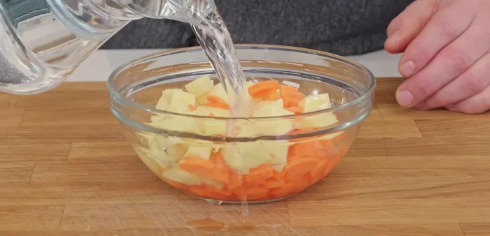 Para acelerar la cocción, colocar la patata y la zanahoria en un bol con agua, cubrir con papel film y llevar al horno durante 4 o 5 minutos.