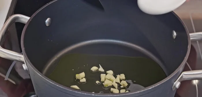 Calentar aceite de oliva en una cazuela a fuego medio. Añadir el ajo picado, la cebolla y el pimiento verde. Sofreír hasta que la cebolla esté transparente y el pimiento tierno.
