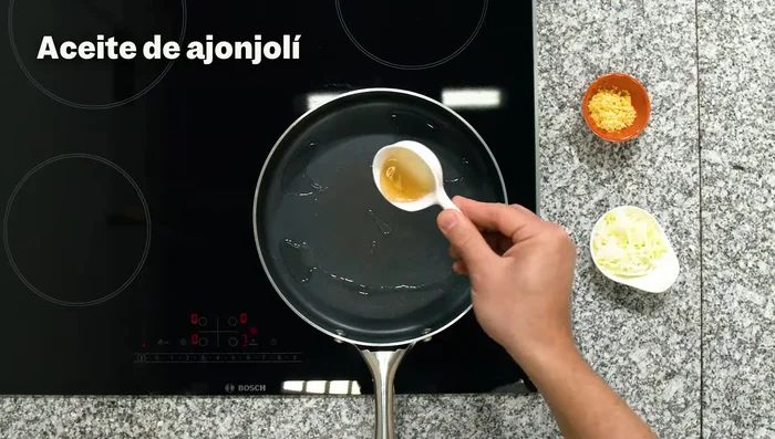 En una sartén, con un poco de aceite de ajonjolí, doramos kion (jengibre) y cebolla china (parte blanca).