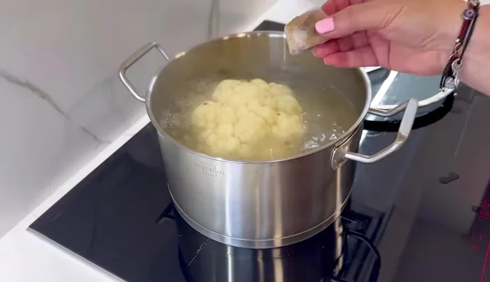 Cocer la coliflor: Cubrir la coliflor con agua en una cacerola. Agregar una pastilla de caldo casero (opcional) para darle más sabor. Llevar al fuego hasta que esté tierna (aprox. 20 minutos).