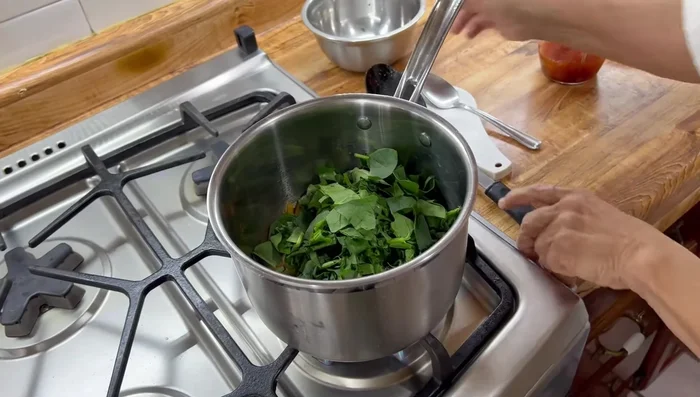 Agregar las espinacas picadas a la olla con el chorizo y la cebolla. Cocer ligeramente.