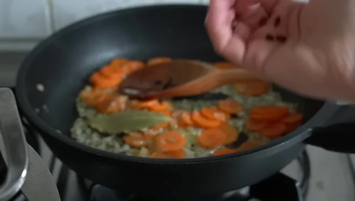 Incorporar hojas de laurel, pepino en rodajas y pimientos de piquillo cortados en tiras.
