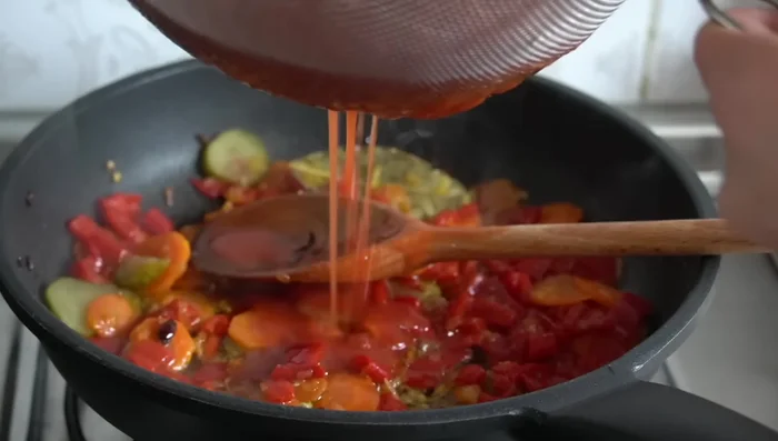 Agregar una lata de tomate triturado pasado por un colador y cocinar la salsa a fuego suave durante 7-10 minutos.