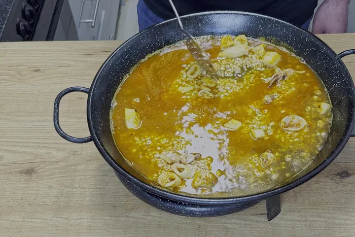 Añadir el fumet de pescado (medio litro). Mezclar bien para que el arroz se tiña uniformemente. (123.119)