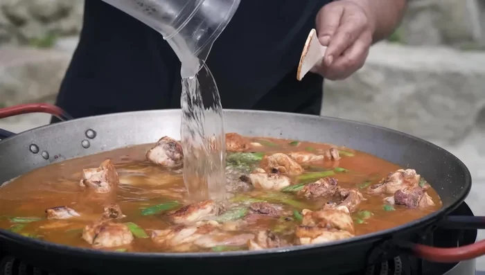 Añadir el agua (3 partes de agua por 1 de arroz para la paella de invierno, cantidad variable para las demás).