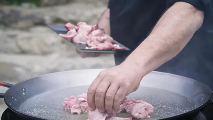 Sofreír la carne (costilla de cerdo, pollo o conejo según la receta).