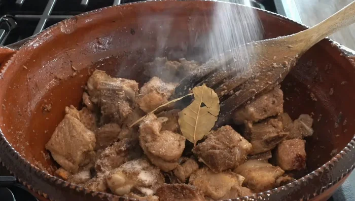 Agregar las hojas de laurel y sal a la carne dorada. Integrar.