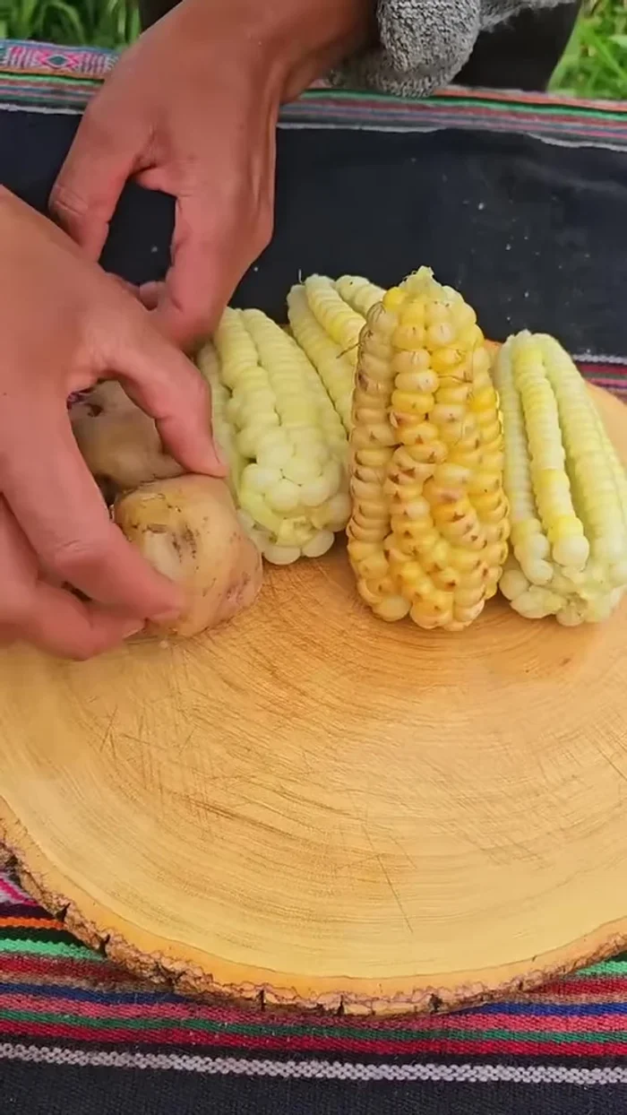Servimos el chicharrón con la ensalada, la papa y el choclo.
