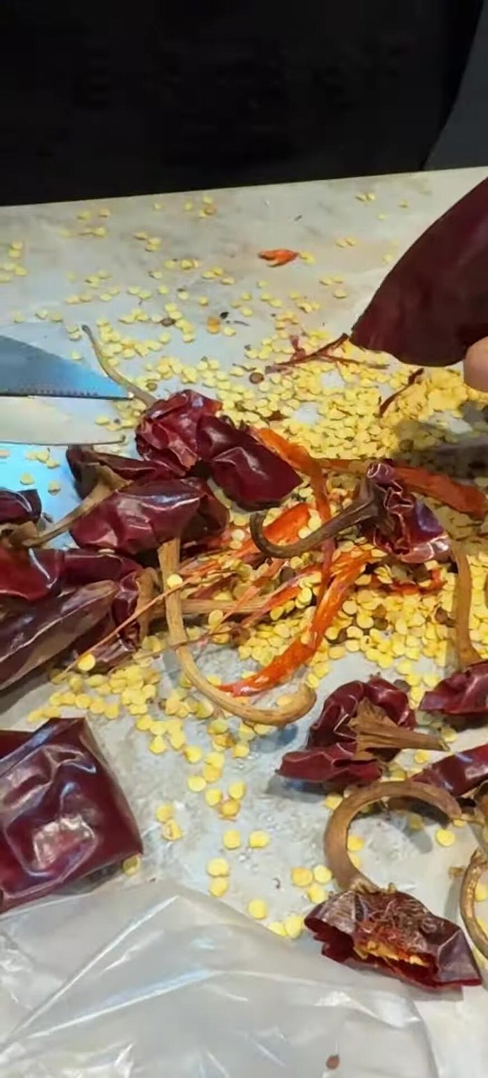 Desvenar los chiles colorados, lavarlos y ponerlos a hervir (59.44). Aproximadamente 30 chiles para 2 kg de manitas (66.56).