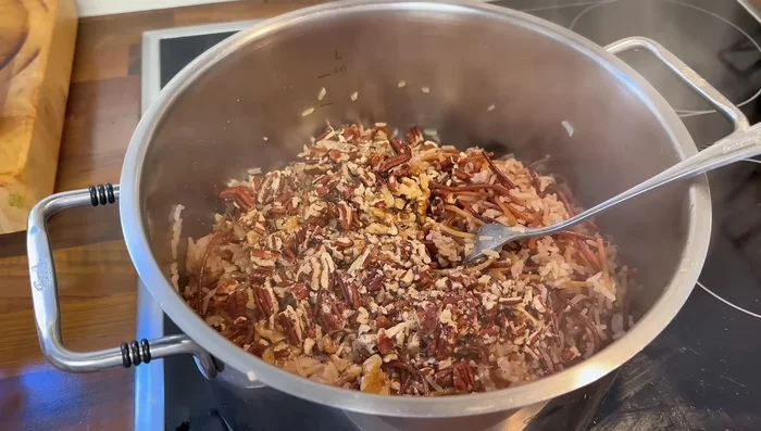 Una vez cocido el arroz, agrega las nueces y las pecanas picadas, y el cerdo. Mezcla bien. (638.68)