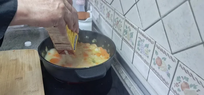 Añadir el caldo de pollo. Llevar a ebullición, tapar, reducir el fuego a medio-bajo y cocinar durante 20 minutos.