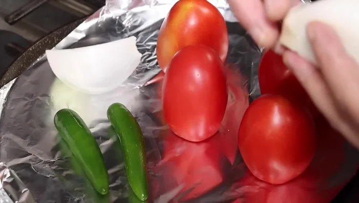 Asa los jitomates, chiles y cebolla (deshojada para una cocción más uniforme).