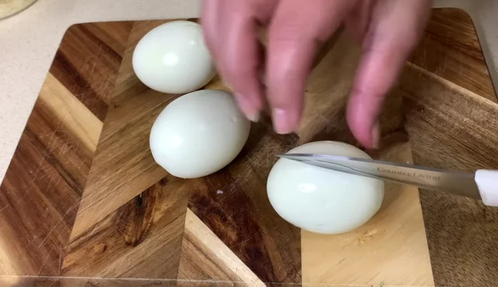 Pelar y cortar los huevos por la mitad.