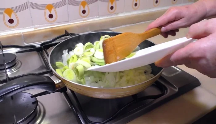 Incorporar los puerros. Tapar la sartén para que el vapor ayude a cocinarlos.