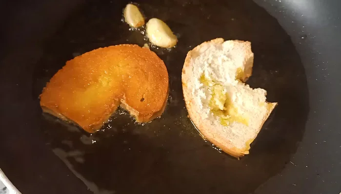 Freír el pan, el ajo y el perejil en aceite de oliva.